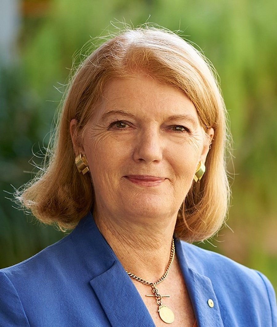 A photo of Hon. Dr. Penelope Wensley, AC. It shows an older, smiling woman with blonde hair. She wears a blue jacket.