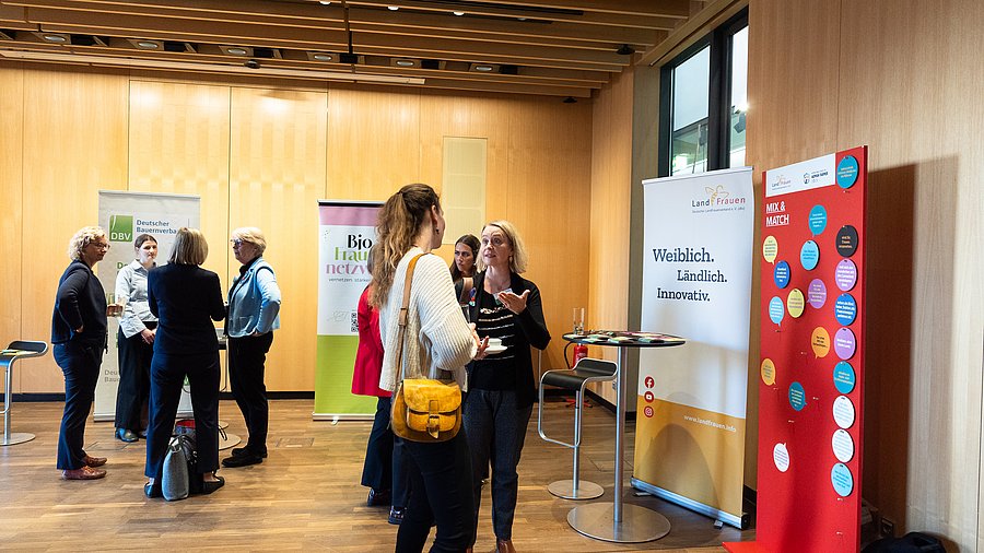 Frauen stehen in Gruppen innerhalb einer Posterausstellung und diskutieren miteinander  anlässlich der Fachkonferenz „Starke Frauen – starke Landwirtschaft“ des Bundesministeriums für Landwirtschaft, Ernährung und Heimat.