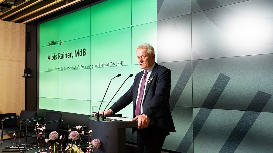 Alois Rainer, Bundesminister für Landwirtschaft, Ernährung und Heimat, steht an einem Rednerpult vor einer Leinwand zur Eröffnung der Fachkonferenz „Starke Frauen – starke Landwirtschaft“.