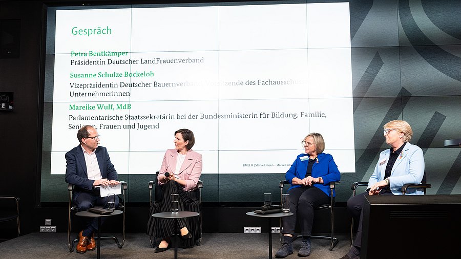 Mareike Wulf, Parlamentarische Staatssekretärin bei der Bundesministerin für Bildung, Senioren, Frauen und Jugend, ist Teil einer Gruppe von Referentinnen und Referenten, die auf einer Bühne anlässlich der Fachkonferenz „Starke Frauen – starke Landwirtschaft“ des Bundesministeriums für Landwirtschaft, Ernährung und Heimat diskutieren.
